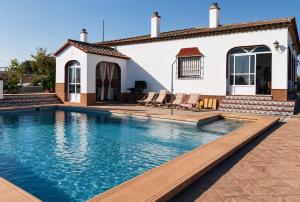 a swimming pool in front of a house at Antigua Villa Medina casa con piscina 3 habitaciones in Marchena +15 photos