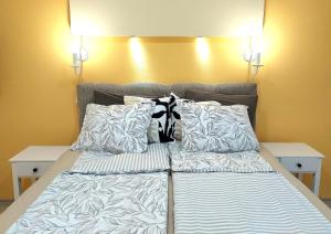 a bed with two pillows on top of it at Amber Apartman in Banja Koviljača +19 photos