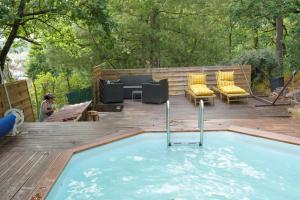 a pool on a wooden deck with chairs and a patio at Nuit au Ranch Horse Paradise & Jacuzzi in Boutigny-sur-Essonnes