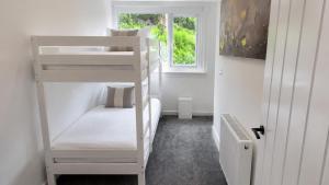 a room with two bunk beds and a window at Bayview at the Port in Port Bannatyne