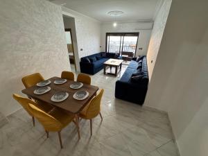 a living room with a wooden table and chairs at Al Hoceima - Vue sur la mer- Green Village Trougout in Al Hoceïma