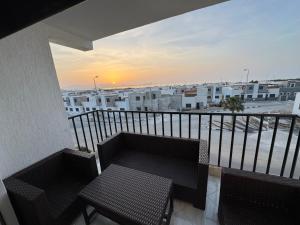 a balcony with a bench and a view of a city at Al Hoceima - Vue sur la mer- Green Village Trougout in Al Hoceïma
