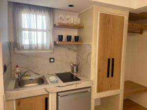 eine kleine Küche mit Spüle und Fenster in der Unterkunft Acti Plaka Hotel in Plaka