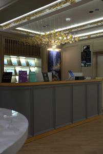 a lobby with a reception counter and lights at Royal Palace Hotel - Al Olaya in Riyadh
