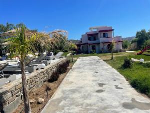 ein Steinpfad, der zu einem Haus mit einer Palme führt in der Unterkunft Acti Plaka Hotel in Plaka