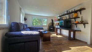 a living room with a blue couch and a table at A casa de Flora in Noya