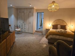 a bedroom with a large bed and a chandelier at Still in Struisbaai