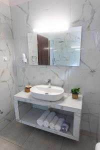 a white bathroom with a sink and a mirror at Sunrise Beach Hotel in Ammoudia +61 photos