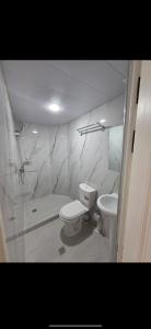 a white bathroom with a toilet and a sink at Rest hotel in Samarkand