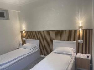 two beds in a small room with at Rest hotel in Samarkand +13 photos
