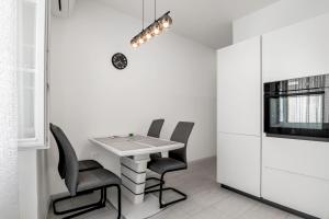 a dining room with a white table and chairs at Apartma Svetlo udobje v Piranu - Bright Comfort Apartment in Piran in Piran +9 photos
