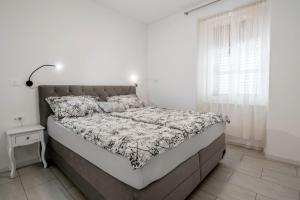 a bed in a white bedroom with a white wall at Apartma Svetlo udobje v Piranu - Bright Comfort Apartment in Piran in Piran