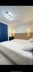 a bedroom with a large white bed and blue curtains at Rest hotel in Samarkand
