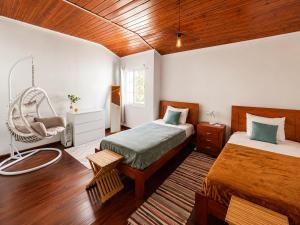 a bedroom with two beds and a chair in it at Botânico Guesthouse in Nordeste