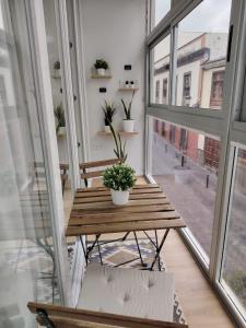 a wooden table in a room with windows at Suites San Agustín 45 - Adults Only in Icod de los Vinos