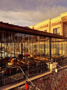 a building with glass windows and tables and chairs at Yeşilsu Taş Konağı in Yeşilsu
