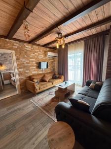 a living room with couches and a brick wall at Yeşilsu Taş Konağı in Yeşilsu