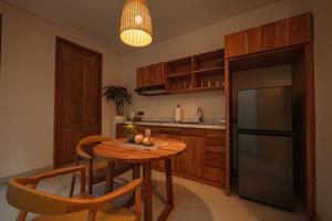 a kitchen with a table and a refrigerator at Apittoya Villas in Gianyar