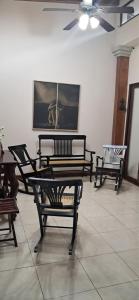a room with chairs and a painting on the wall at Hostal Casa Las Flores in Masaya