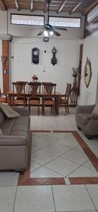a living room with a couch and a table and chairs at Hostal Casa Las Flores in Masaya