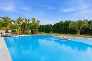 a large blue swimming pool with two chairs in it at Spot Troia - Boutique Suites in Troia