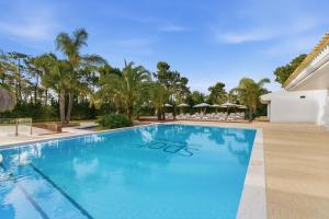 a swimming pool at a resort with palm trees at Spot Troia - Boutique Suites in Troia