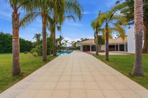 a walkway lined with palm trees in front of a house at Spot Troia - Boutique Suites in Troia