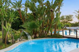 a swimming pool with a waterfall in a resort at Spot Troia - Boutique Suites in Troia