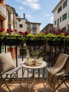 a table and chairs on a balcony with flowers at CaL QuEROL Select One in Puigcerdà