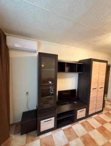 a living room with a entertainment center with a tv at Odesa Krasna, 8 Apart in Odesa