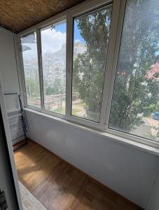 an empty room with three windows in a building at Odesa Krasna, 8 Apart in Odesa +3 photos