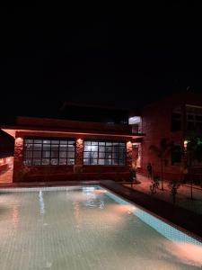 a swimming pool in front of a building at night at Jawai Mount Town in Mori Bera