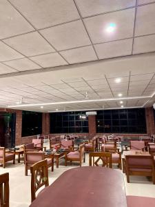 a dining room with wooden tables and chairs at Jawai Mount Town in Mori Bera