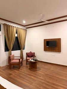a living room with a tv and a chair and a table at Jawai Mount Town in Mori Bera