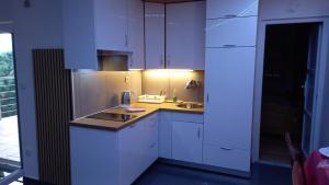a kitchen with white cabinets and a sink at D,apartman' ulica pušća 51, 51513 Omišalj in Omišalj