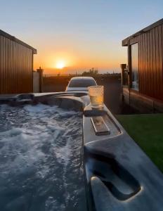 a jacuzzi tub with a sunset in the background at Carberry Lodge in Musselburgh