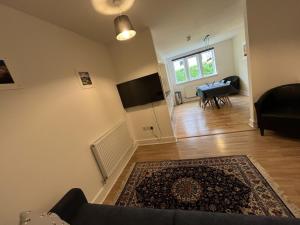 a living room with a couch and a table and a television at Ancluaran - Moat House 10 in Fort Augustus