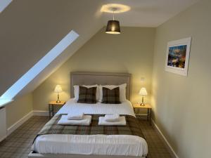 a bedroom with a large bed with two night stands at Ancluaran - Moat House 10 in Fort Augustus +11 photos