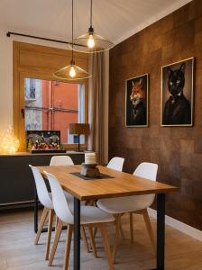 a dining room with a wooden table and white chairs at CaL QuEROL Select One in Puigcerdà