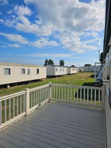 a deck with a view of a row of mobile homes at 3 bed static van with decking in Dymchurch