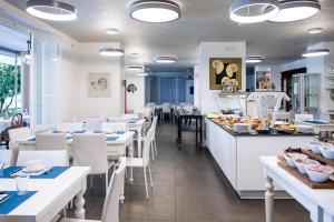 a restaurant with white tables and white chairs at Hotel Clelia in Deiva Marina