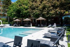 a swimming pool with lounge chairs and umbrellas at Hotel Clelia in Deiva Marina