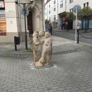 a statue of three people on the side of a street at Pension Anna in Löbau