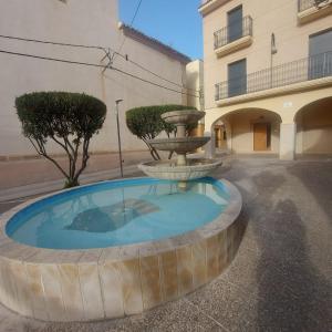 a fountain in a courtyard next to a building at Casa de angil in Tivenys