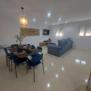 a living room with a table and a blue couch at Casa de angil in Tivenys