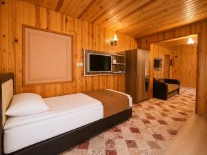 a bedroom with a bed and a television in a room at Şekersu Otel in Çaykara