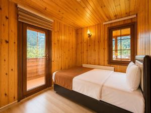 a bedroom with a bed and a large window at Şekersu Otel in Çaykara