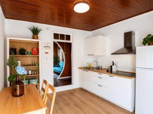 a kitchen with white cabinets and a wooden table at Botânico Guesthouse in Nordeste +15 photos