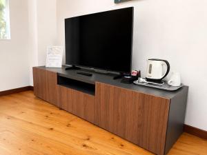 a flat screen tv on a wooden entertainment center at Milano Brenta Suites Room for 4 in Milan