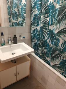 a bathroom with a sink and a shower curtain at Home luna &zeus in Lausanne